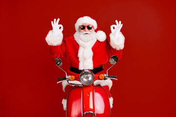 Portrait of his he nice confident cheery lucky Santa riding moped showing double ok-sign advert winter season discount isolated bright vivid shine vibrant yellow color background