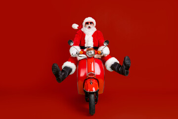 Portrait of his he nice funny amazed stunned childish comic crazy Santa riding moped having fun...