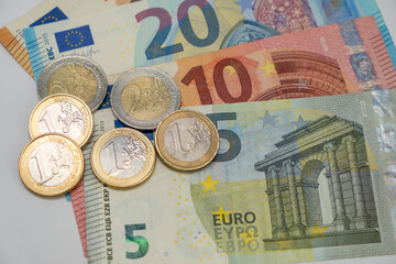 One and two euro coins on top of Euro Bank Notes in a table. Euro money concept.