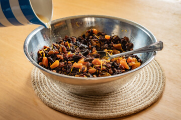Preparing the fruit to make a Christmas cake, pouring in brandy