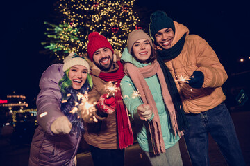 Photo of excited positive buddies hands hold bengal fires sticks newyear festive spirit city center...