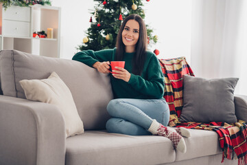 Obraz premium Photo of charming pretty girl wear xmas green pullover enjoying tasty hot beverage indoors home room
