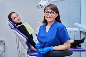 Portrait of female dentist with girl patient sitting in dental chair