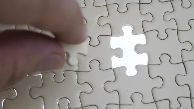 Hand holding jigsaw puzzle last missing piece lighting. 
Concept last piece of jigsaw puzzle for problem and 
completion.