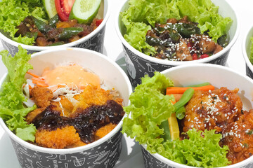 Fried chicken in spicy sauce sprinkled with sesame and chicken katsu with vegetables isolated on white background. fast food concept