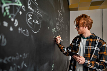 Young man with digital tablet writing math formula