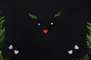 Christmas or New Year dark background, christmas deer. Xmas black board framed with season decorations, space for a text, view from above.