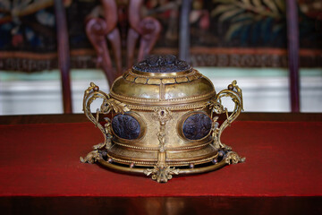 Antique gilt decorative box with lock on red velvet table