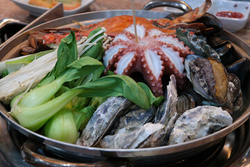 Steamed dish with various vegetables, octopus, abalone, and seafood