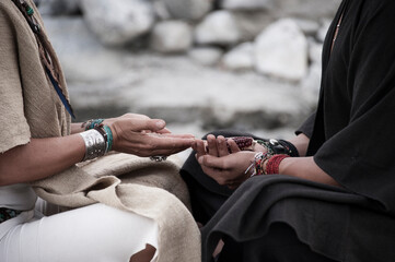 Shamanic ritual offering traditional corn.  Photograph of two shaman's hands.  - 549246982