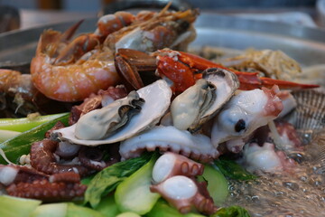 Steamed dish with various vegetables, octopus, abalone, and seafood