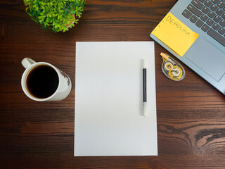 Flat lay, a mockup of a notebook. A workspace with white notebooks, laptops, office supplies, pencils, and coffee cups in the office background of a wooden desk from top view.