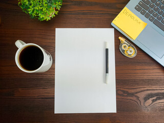 Flat lay, a mockup of a notebook. A workspace with white notebooks, laptops, office supplies, pencils, and coffee cups in the office background of a wooden desk from top view.