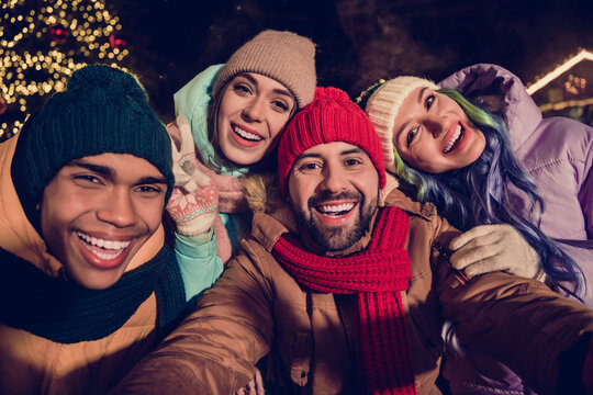 Photo Of Funky Cheerful Four Buddies Wear Windbreakers Embracing Recording Video Xmas Vlog Blog Together Outside Urban Market Park