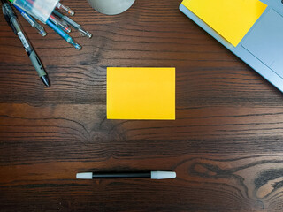 Flat lay, a mockup of a notebook. A workspace with white notebooks, laptops, office supplies,and coffee cups in the office background of a wooden desk from top view.
