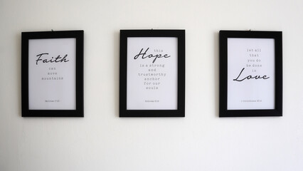 Religious texts in photo frames on the wall about faith, hope and love and principles of life based...