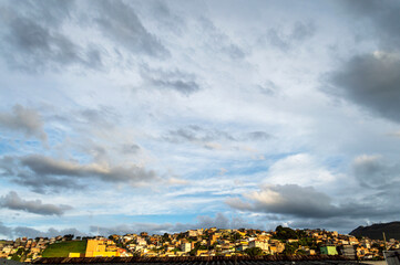 Beautiful landscape with blue sky many clouds and houses at the top of the hill.