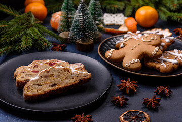 Delicious festive New Year's pie with candied fruits, marzipan and nuts on a dark concrete background