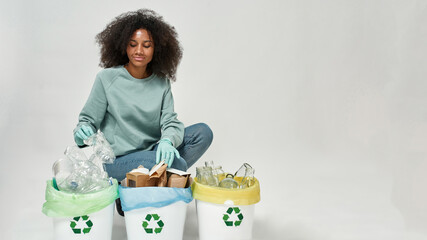 Young black girl sort garbage in variety dustbins