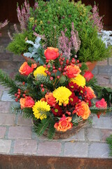 Naklejka premium Gesreck mit Blumen in Geld und Orange auf dem Friedhof im Herbst