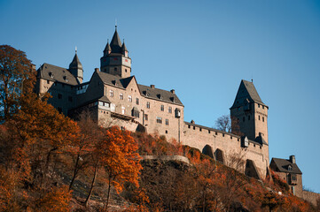 Fototapeta na wymiar Altena Castle “Burg Altena“ in Sauerland Germany is a famous Landmark monument in the Lenne Valley and Mediaval Sight with First Youth Hostel of the World on a sunny colorful autumn day