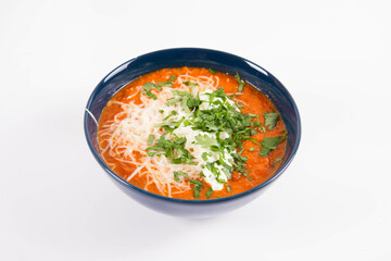 Italian tomato soup served with cream, mozzarella cheese and fresh parsley in a bowl, on a white backgound	
