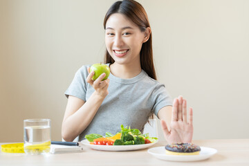 Diet, Dieting asian young woman or girl use hand push out, deny sweet donut and choose green salad...