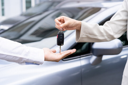 Business car rental, sell or buy service, dealership hand of agent dealer, sale young woman giving auto key of vehicle to customer renter, buyer man receiving, client or tenant, transfer automobile.