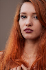 Close-up portrait of arrogant beautiful slim girl with long red hair