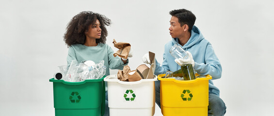 Girl and man sorting garbage in variety dustbins