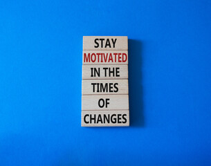 Motivation and changes symbol. Concept words Stay motivated in the times of changes on wooden blocks. Beautiful blue background. Business concept. Copy space.