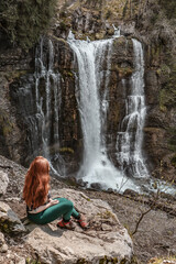 Woman enjoying the beauty of waterfalls. 