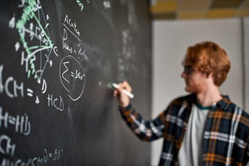 Math formula near blurred man write on blackboard