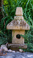 Garden decorations made of stones and stone sculptures among nice greens.