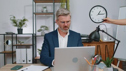 Mature old businessman programmer software developer working on laptop at office with anxiety checking time on clock, being in delay, deadline. Concentrated freelancer business man worrying to be late