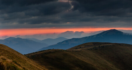 Amazing panoramic mountains landscape at dawn. View of dramatic morning sky and mountain ridges and slopes.