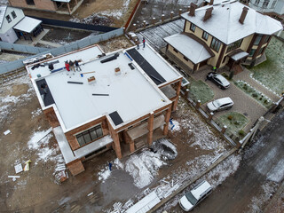 Roofing construction worker installing a flat roof. Bright blue sky in the background.