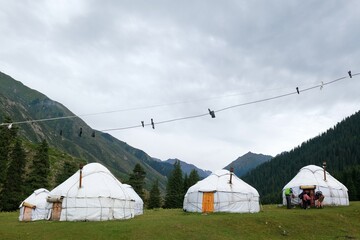 Yurt camp in Karakol Mountains, Tien Shan Mountains, Kyrgyzstan, Central Asia. Traditional nomad's yurts on green mountain meadow in summer. 