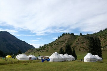 Yurt camp in Karakol Mountains, Tien Shan Mountains, Kyrgyzstan, Central Asia. Traditional nomad's yurts on green mountain meadow in summer. 