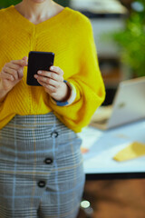 Elegant business owner woman in green office using smartphone