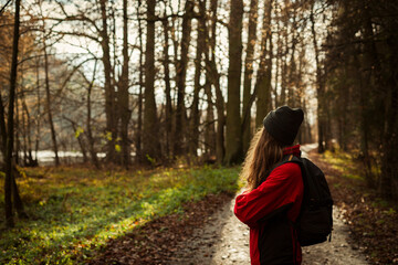 young tourist woman on a trail in an autumnal forest. A single independent courageous and happy...