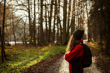 young tourist woman on a trail in an autumnal forest. A single independent courageous and happy woman.