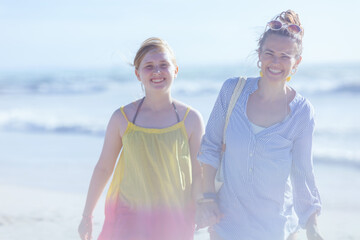 Portrait of smiling modern mother and child at beach walking