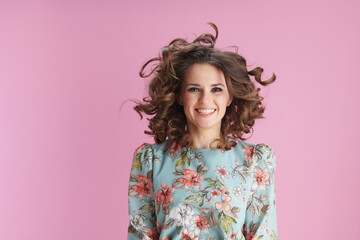 happy trendy woman in floral dress jumping on pink