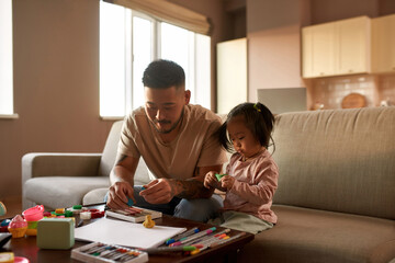 Father and daughter sculpt with plasticine at home