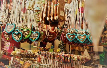 Fototapeta premium Weihnachtsmarktstand mit hängenden bunten Lebkuchenherzen und Süßigkeiten am Nachmittag im Winter