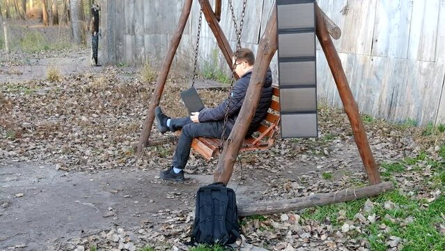 Man work on laptop charginf portable solar panel