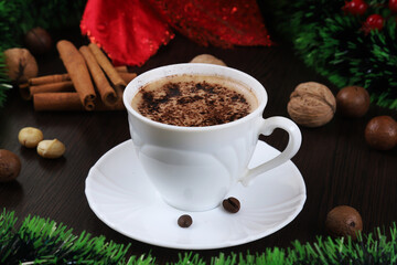 Cappuccino coffee in a white cup on the Christmas table, New Year. Close-up