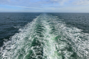 Blick vom Heck eines Kreuzfahrtschiffes auf die Heckwelle im Meer