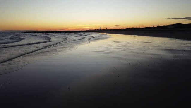 Aerial shot of Eraclea beach with sand, waves and stones, Veneto